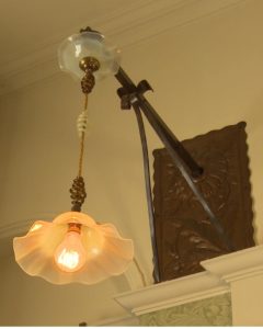 A sunflower-inspired wall-light from the Drawing Room at Standen.